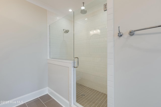 bathroom featuring baseboards, tile patterned floors, and a stall shower