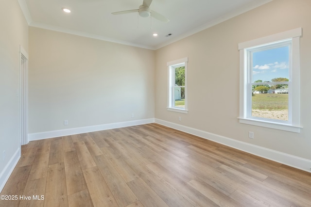 empty room with ceiling fan, baseboards, crown molding, and light wood finished floors