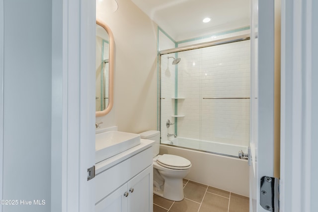 bathroom with vanity, tile patterned flooring, shower / bath combination with glass door, and toilet