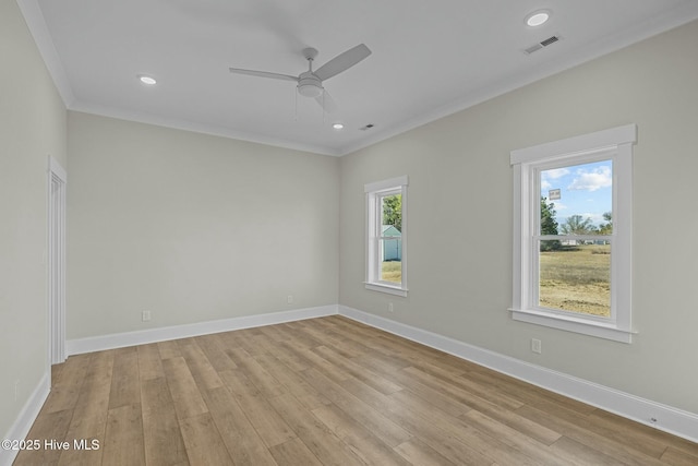 empty room featuring visible vents, baseboards, and light wood finished floors