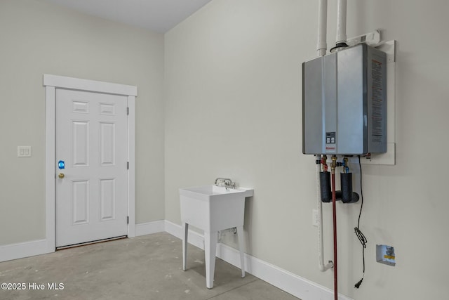 laundry area with baseboards, water heater, and laundry area