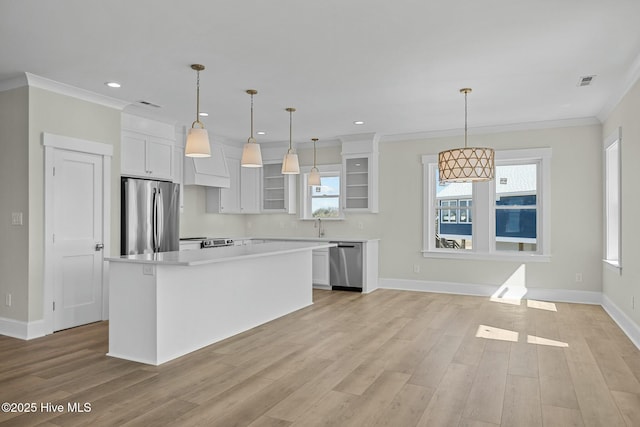 kitchen featuring glass insert cabinets, crown molding, light countertops, appliances with stainless steel finishes, and white cabinets