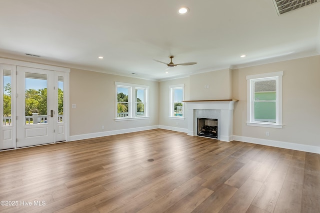 unfurnished living room with visible vents, crown molding, ceiling fan, and a healthy amount of sunlight