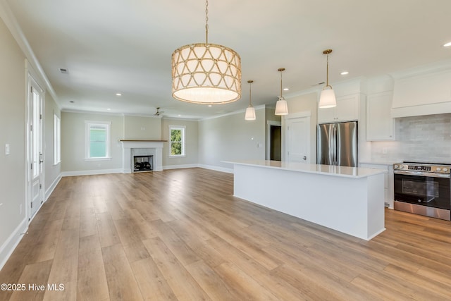 kitchen with stainless steel appliances, recessed lighting, white cabinetry, and ornamental molding