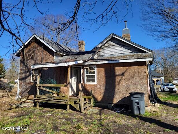 back of house with a chimney