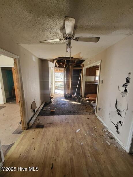 interior space featuring ceiling fan, wood finished floors, and a textured ceiling