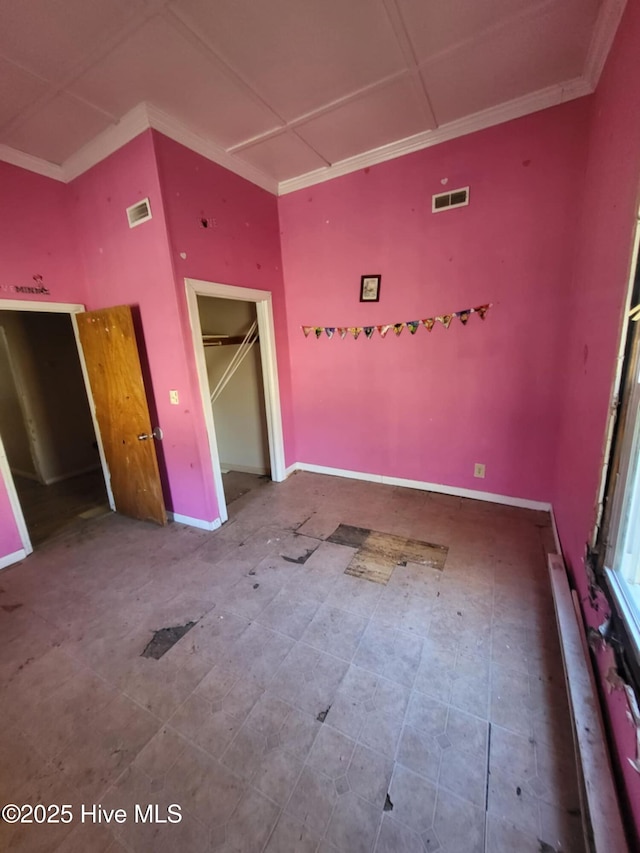 unfurnished bedroom with baseboards, visible vents, a closet, and ornamental molding