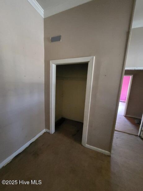 interior space featuring crown molding and baseboards