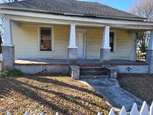 view of front of home with covered porch and roof with shingles