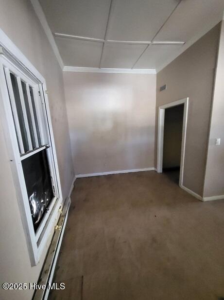 unfurnished room with a baseboard radiator, baseboards, and carpet floors