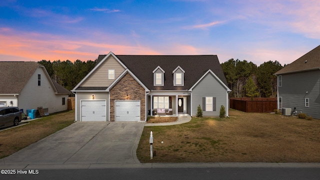 traditional-style home with stone siding, a yard, central air condition unit, and concrete driveway