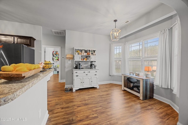 dining room with visible vents, arched walkways, and dark wood-style flooring