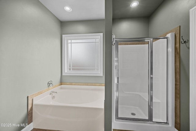 bathroom featuring a bath, recessed lighting, and a stall shower