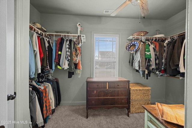 walk in closet with a ceiling fan, visible vents, and carpet floors