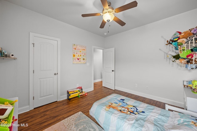 bedroom with a ceiling fan, wood finished floors, and baseboards