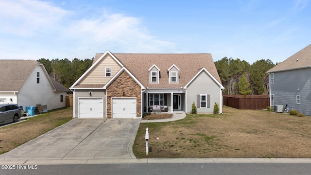 traditional-style house with stone siding, central AC, concrete driveway, and a front yard