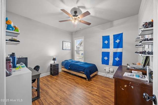 bedroom with ceiling fan, baseboards, and wood finished floors