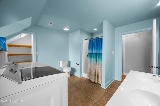 bathroom featuring a sink, visible vents, toilet, and washing machine and clothes dryer