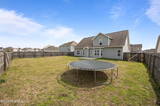 view of yard featuring a trampoline and a fenced backyard