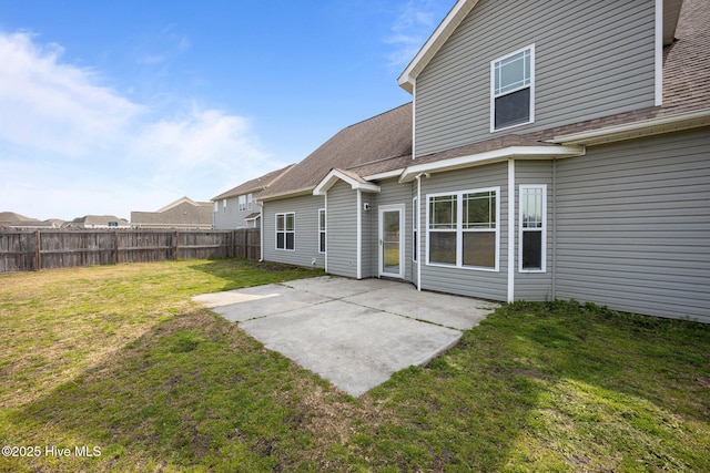 back of house with a yard, fence, roof with shingles, and a patio area