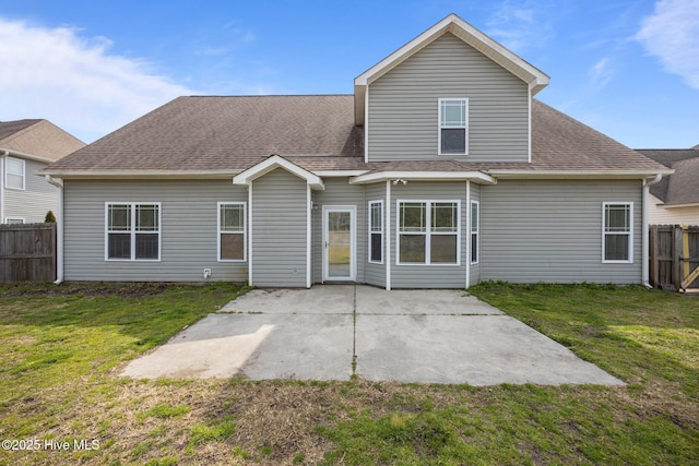 back of house with a patio area, a lawn, roof with shingles, and fence