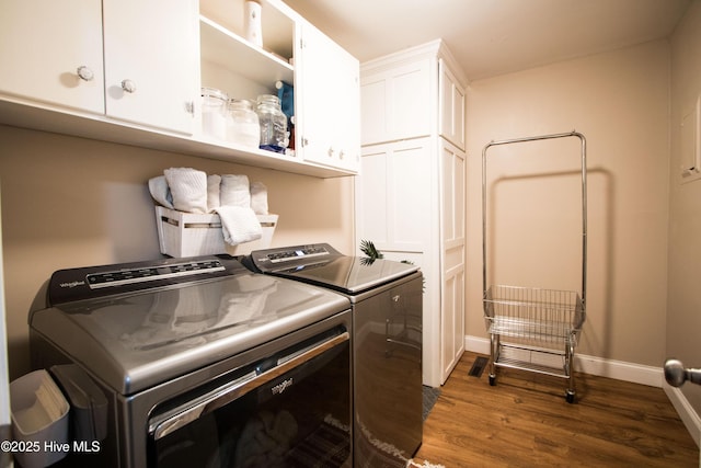 laundry room featuring washer and dryer, baseboards, cabinet space, and wood finished floors