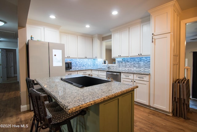 kitchen featuring tasteful backsplash, stainless steel appliances, dark wood-style flooring, and a center island