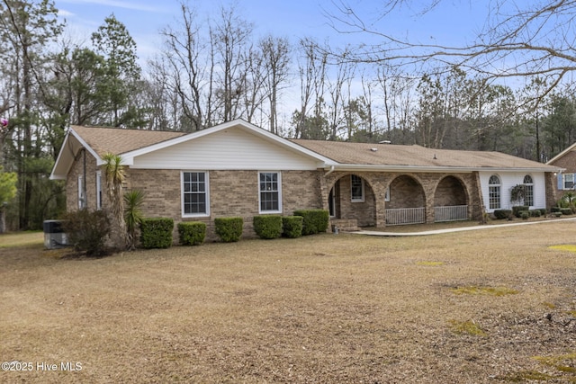 single story home featuring covered porch, brick siding, and a shingled roof