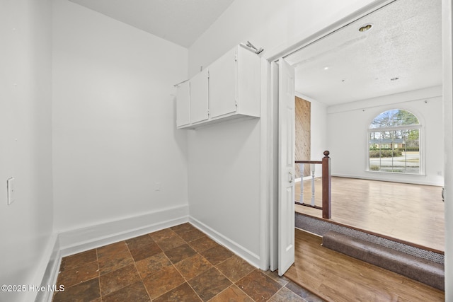 walk in closet with stone tile floors