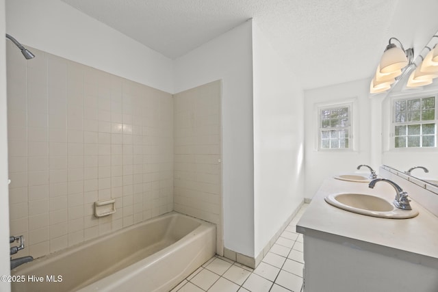 full bath featuring a sink, baseboards, a textured ceiling, and tile patterned flooring