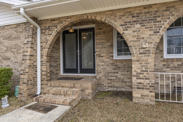 view of exterior entry featuring brick siding