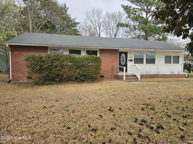 ranch-style home with crawl space, a shingled roof, a front lawn, and brick siding
