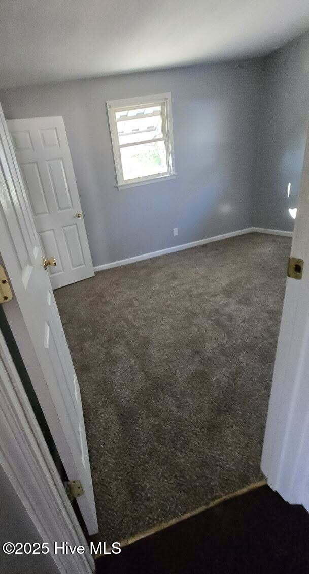 spare room with carpet flooring and baseboards