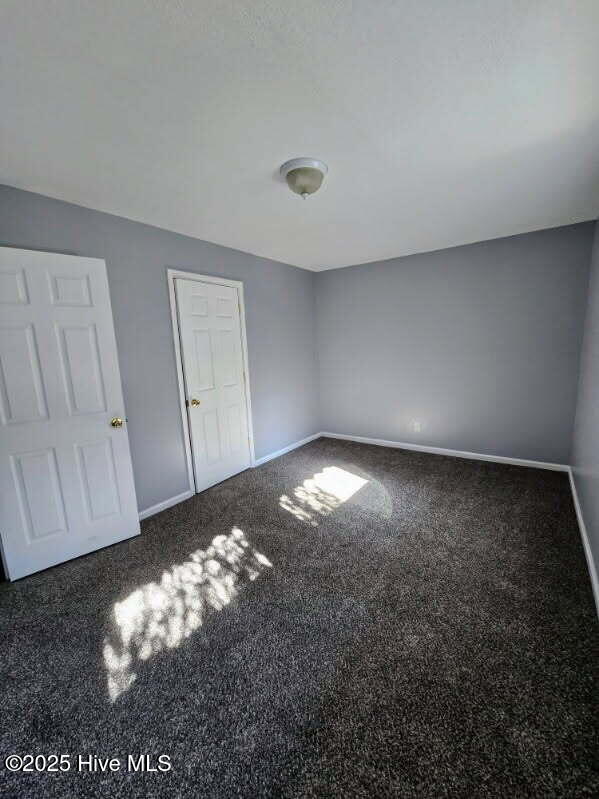 unfurnished bedroom featuring baseboards and carpet floors