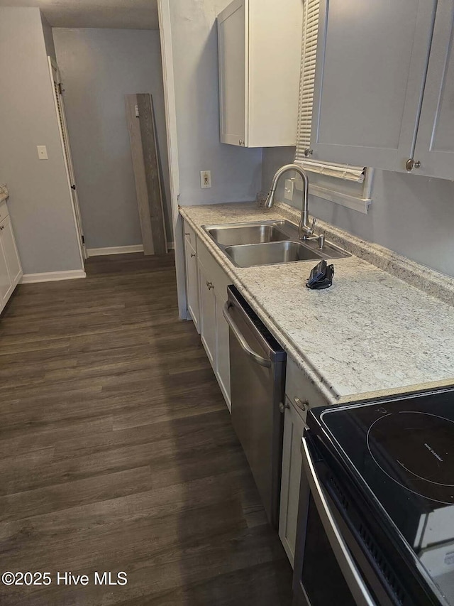 kitchen with dark wood finished floors, black / electric stove, light countertops, stainless steel dishwasher, and a sink