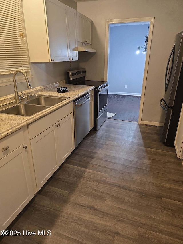 kitchen featuring under cabinet range hood, stainless steel appliances, dark wood-type flooring, and a sink