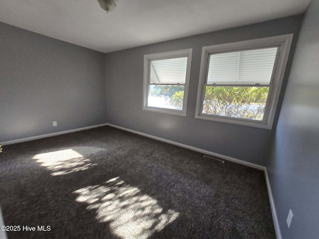 carpeted spare room with visible vents and baseboards