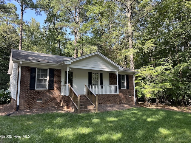 view of front of home featuring brick siding, a porch, a front yard, roof with shingles, and crawl space