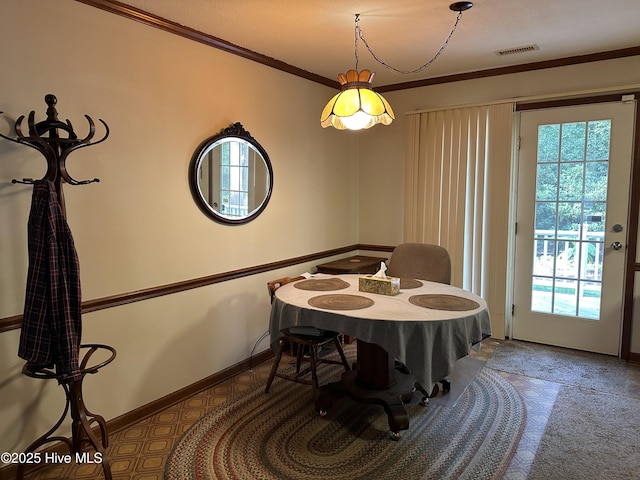 dining space with baseboards, a healthy amount of sunlight, visible vents, and ornamental molding