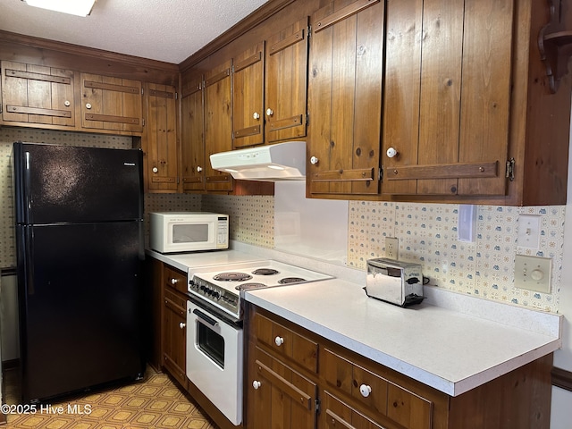 kitchen with under cabinet range hood, white appliances, light floors, and light countertops