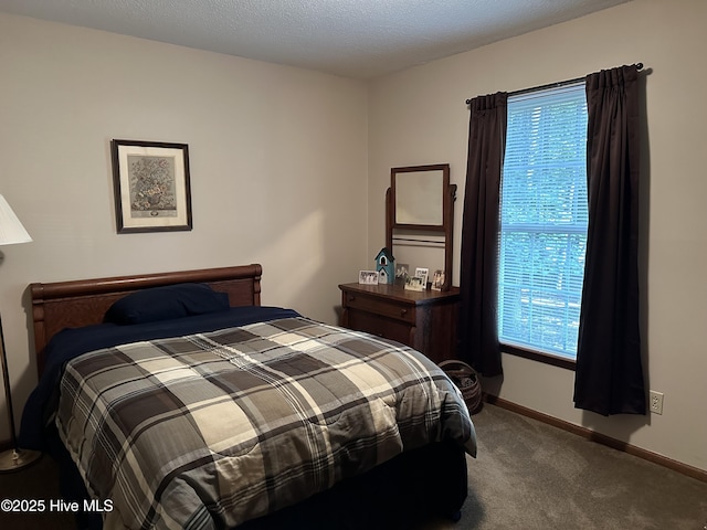 carpeted bedroom featuring baseboards and a textured ceiling