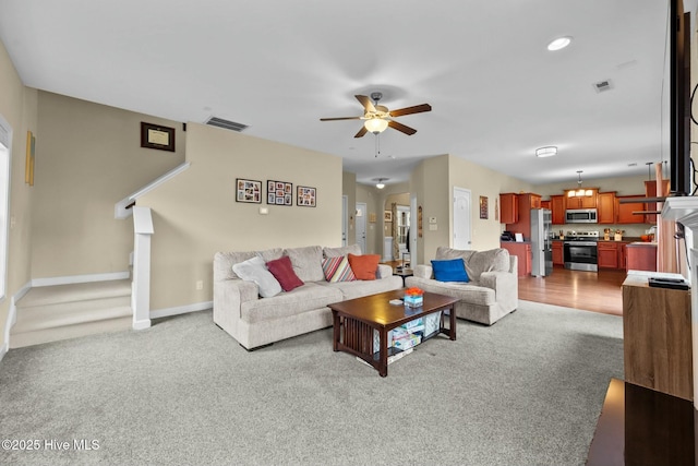 carpeted living room featuring visible vents, baseboards, and a ceiling fan