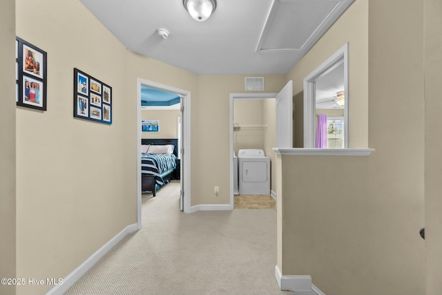 hall with visible vents, carpet flooring, washer / clothes dryer, and baseboards