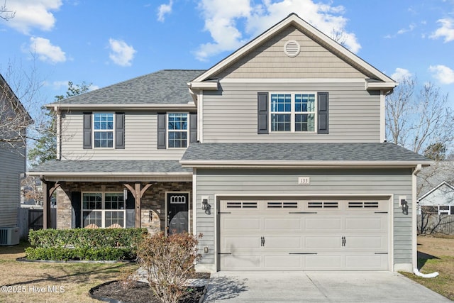 traditional home with a porch, concrete driveway, roof with shingles, a garage, and stone siding