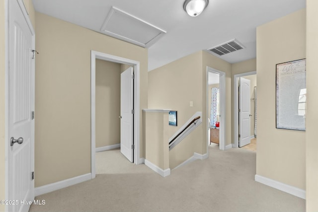 corridor featuring carpet, visible vents, baseboards, attic access, and an upstairs landing