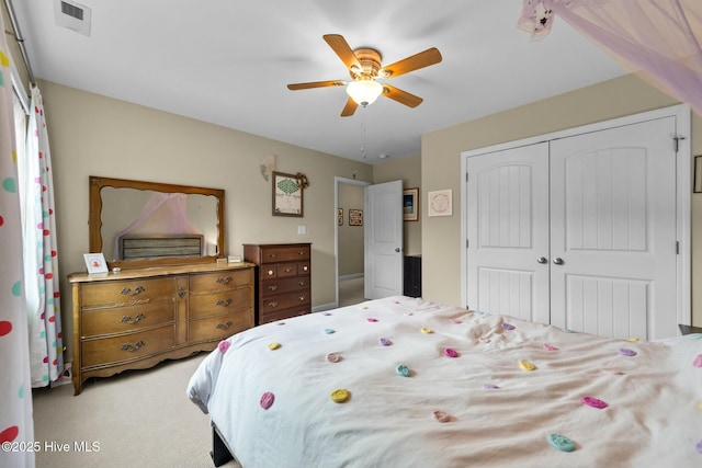 bedroom featuring visible vents, a ceiling fan, a closet, and light carpet