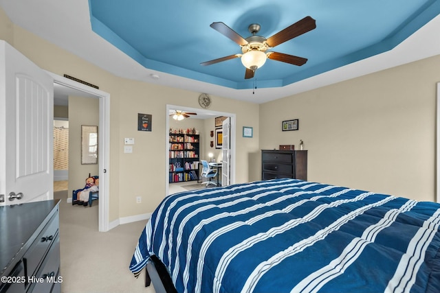 bedroom with light carpet, ceiling fan, a raised ceiling, and baseboards