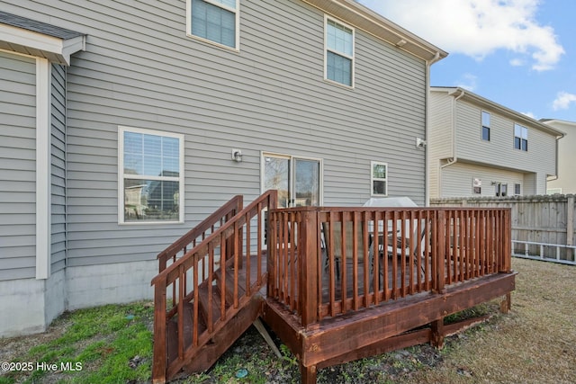 back of property with a wooden deck and fence