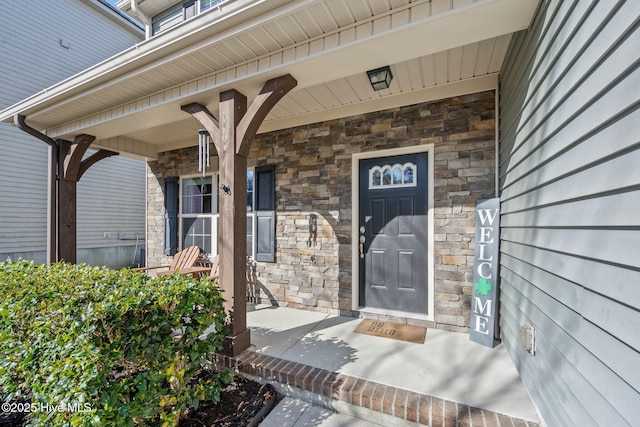 property entrance with stone siding and a porch