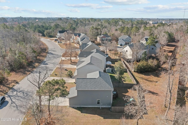 drone / aerial view featuring a forest view and a residential view